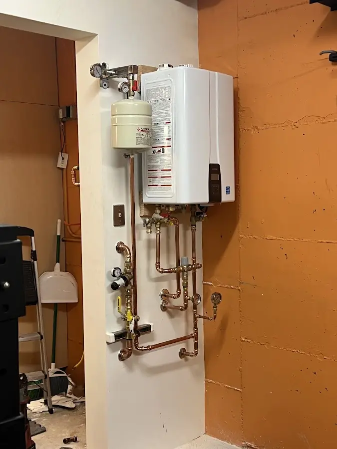 Plumbing technician inspecting water heater connections in San Dimas